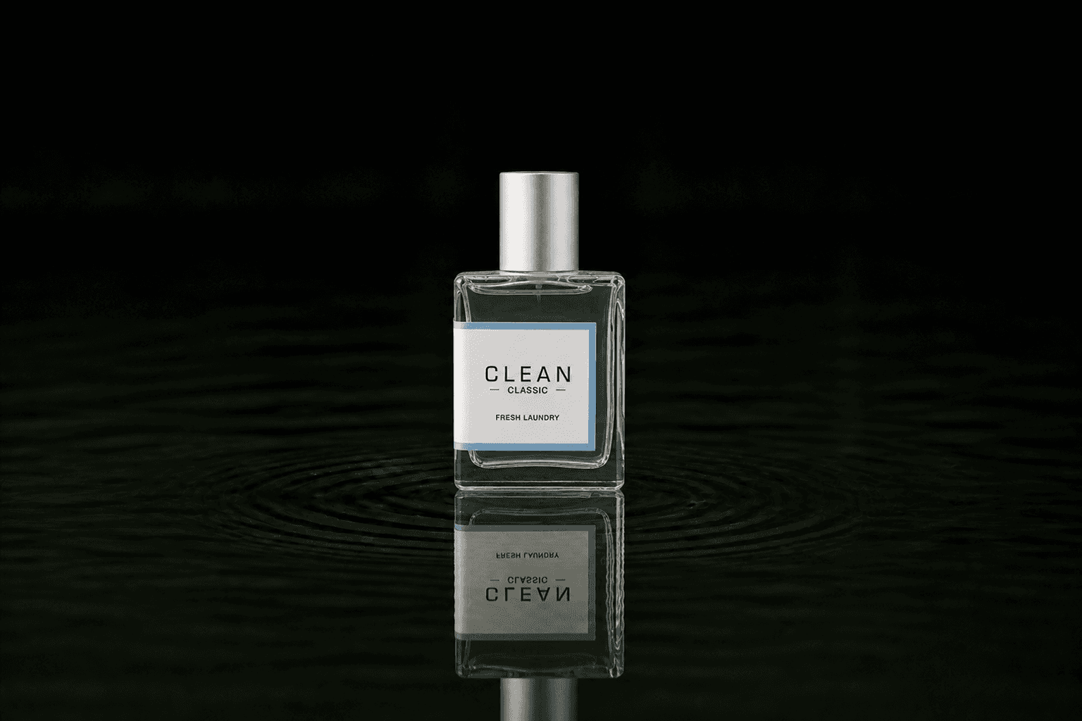 Clean Fresh Laundry fragrance bottle floating above dark water