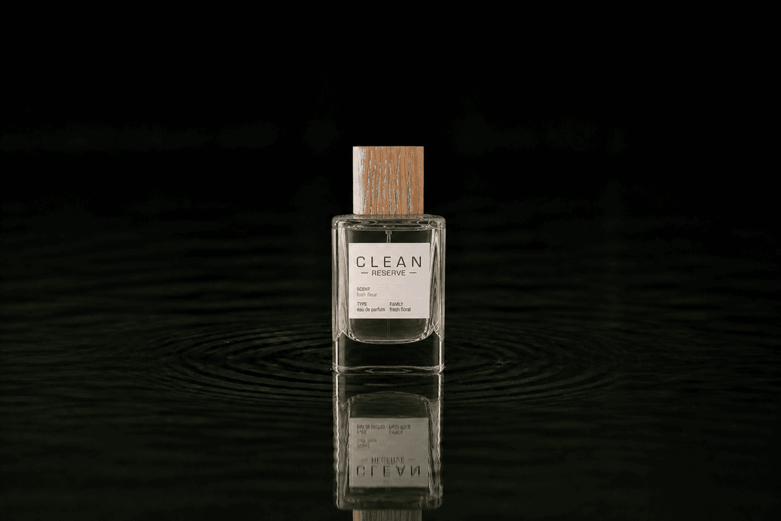 Clean Lush Fleur fragrance bottle floating above dark water