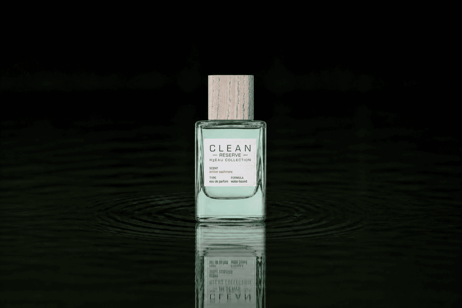 Clean Reserve H2EAU Amber Cashmere fragrance bottle floating above dark water