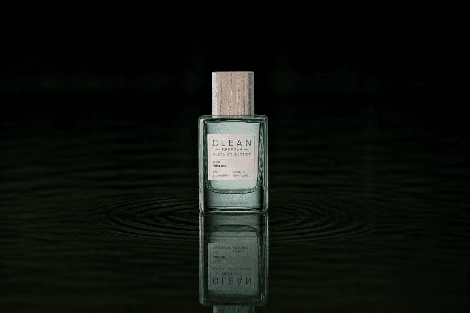 Clean Reserve H2EAU Musk Noir fragrance bottle floating above dark water