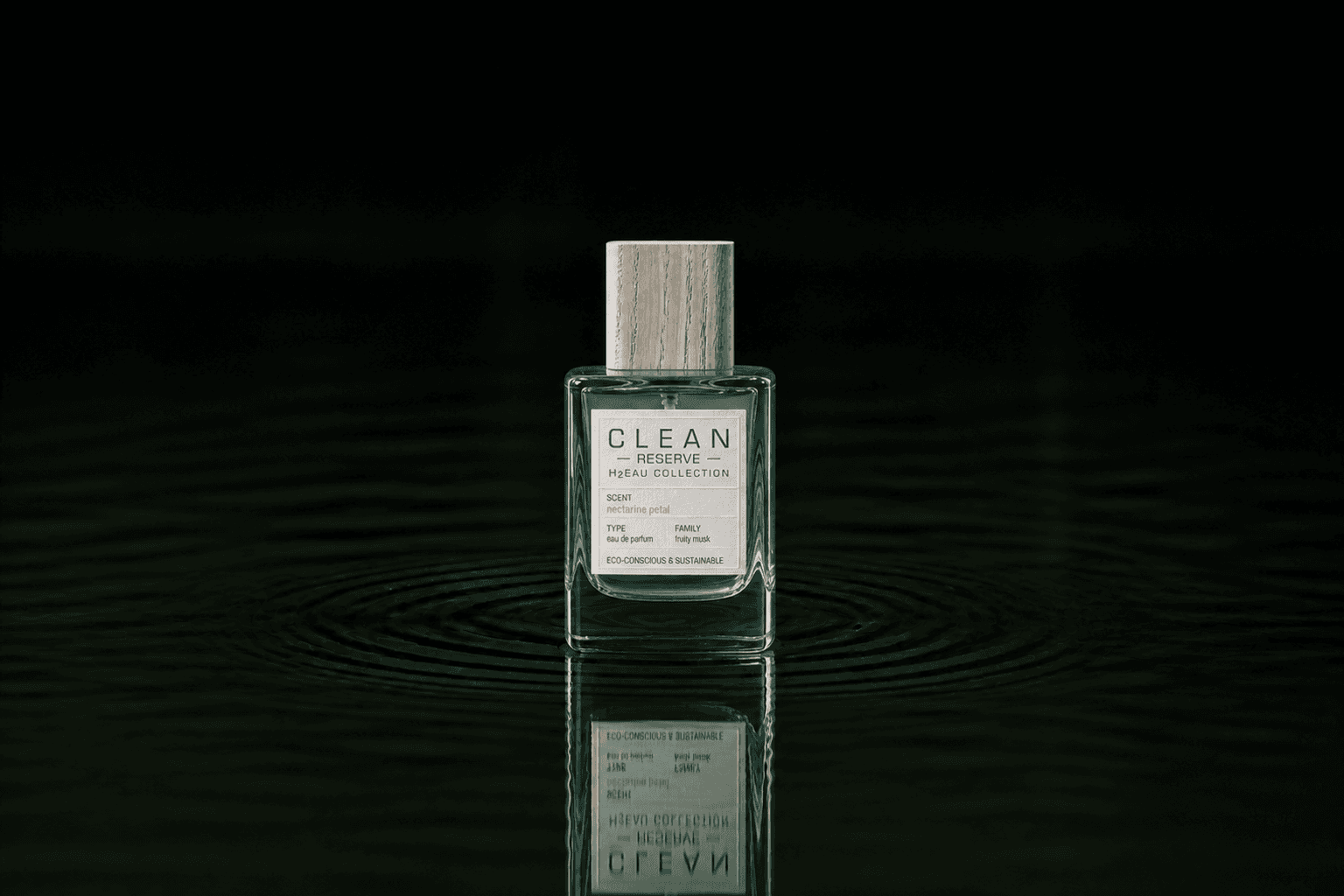 Clean Reserve H2EAU Nectarine Petal fragrance bottle floating above dark water