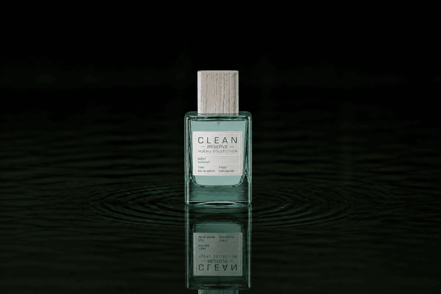 Clean Reserve H2EAU Waterfall fragrance bottle floating above dark water