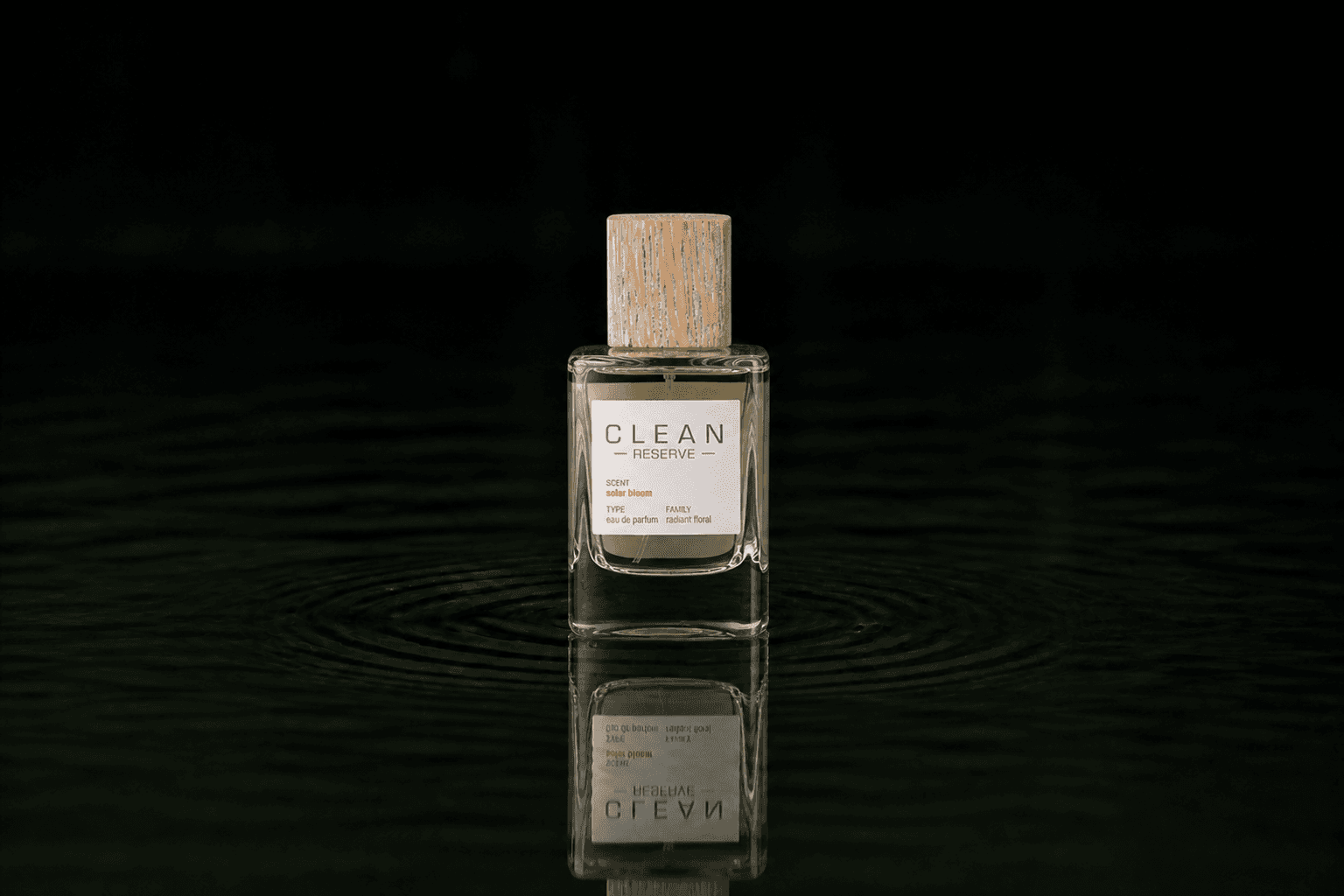Clean Reserve - Solar Bloom fragrance bottle floating above dark water