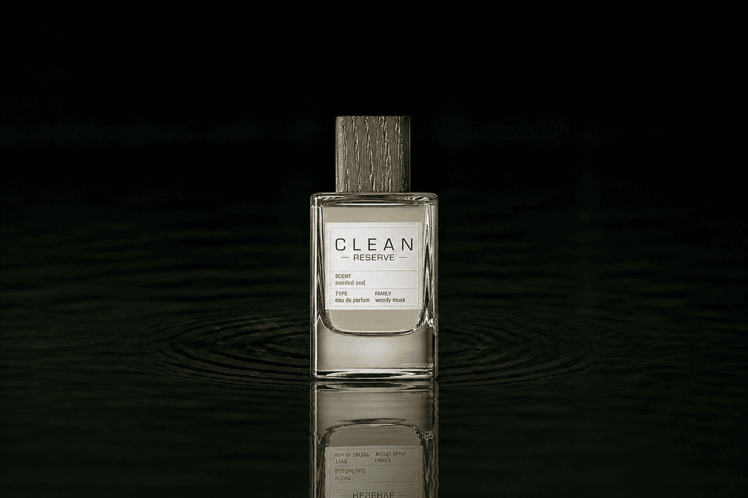 Clean Sueded Oud fragrance bottle floating above dark water