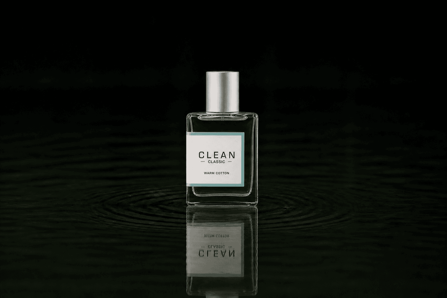 Clean Warm Cotton fragrance bottle floating above dark water