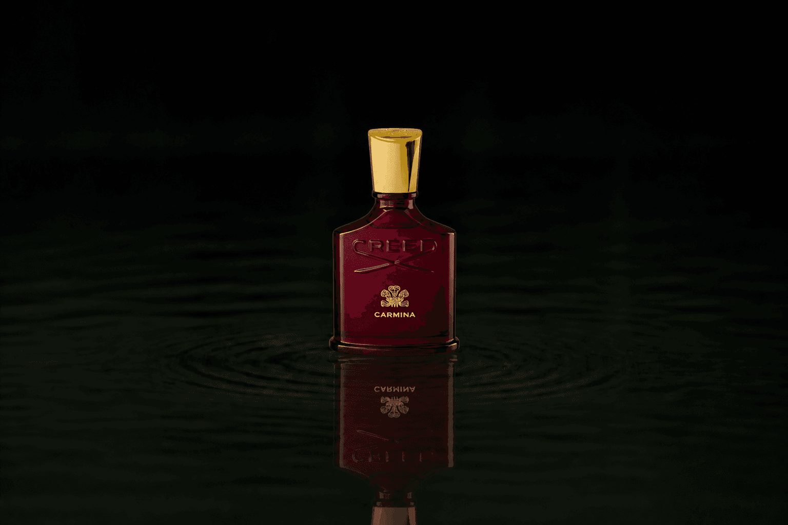 Creed Carmina fragrance bottle floating above dark water
