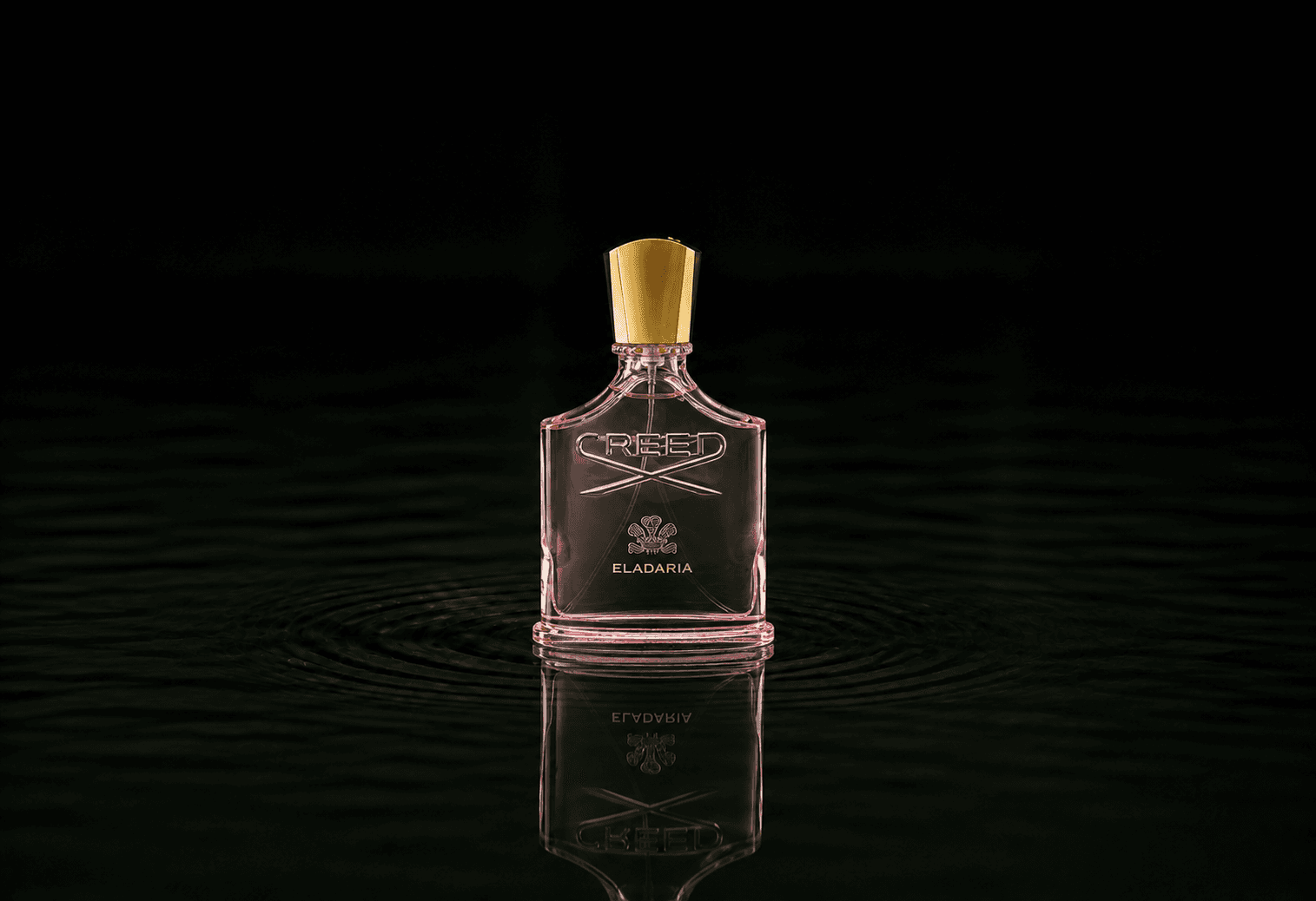 Creed Eladaria fragrance bottle floating above dark water
