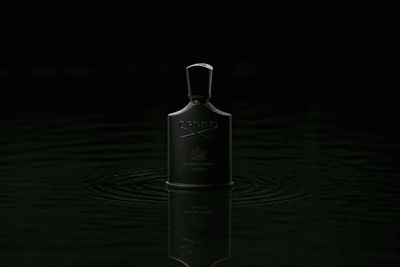 Creed Green Irish Tweed fragrance bottle floating above dark water