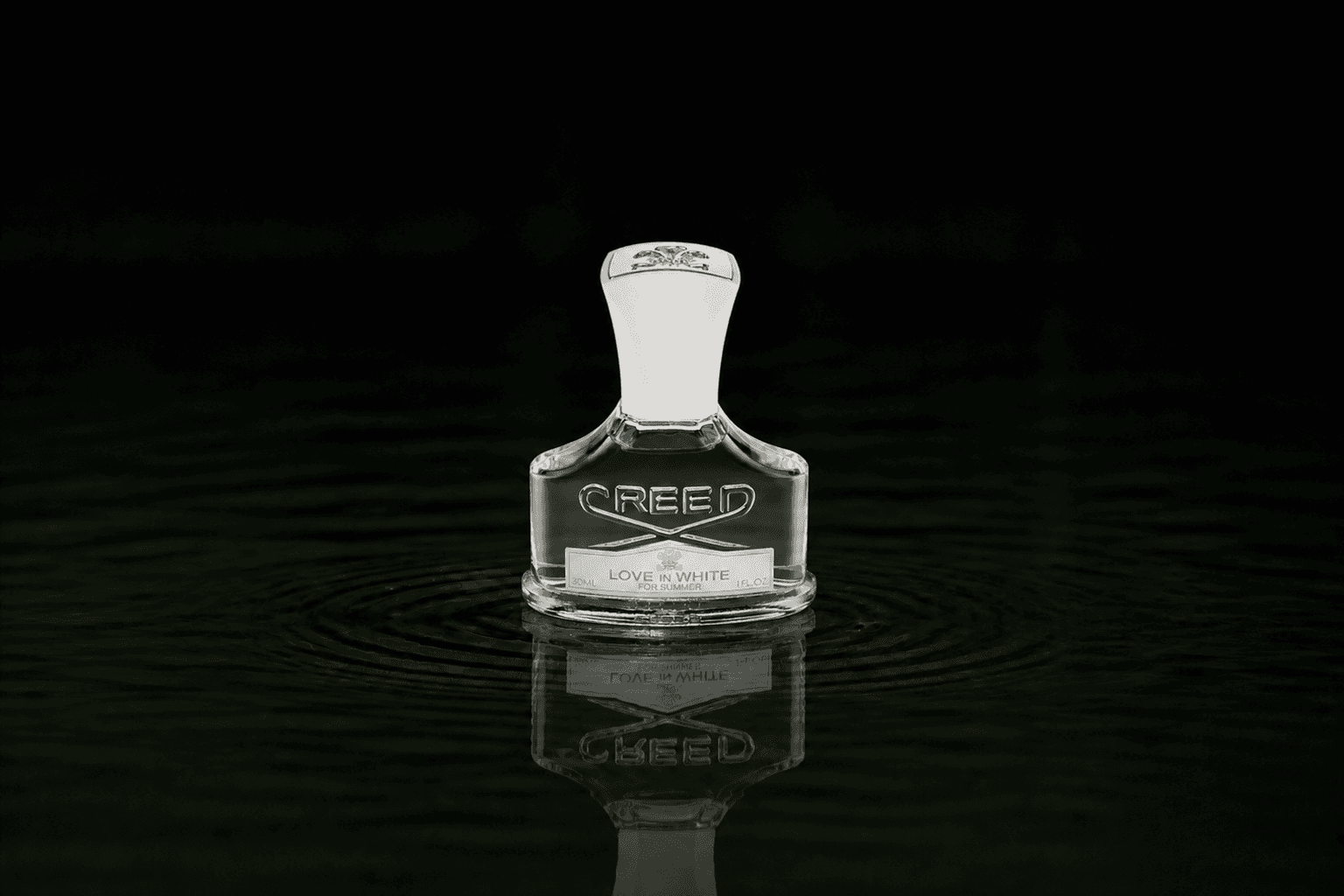 Creed Love in White for Summer fragrance bottle floating above dark water