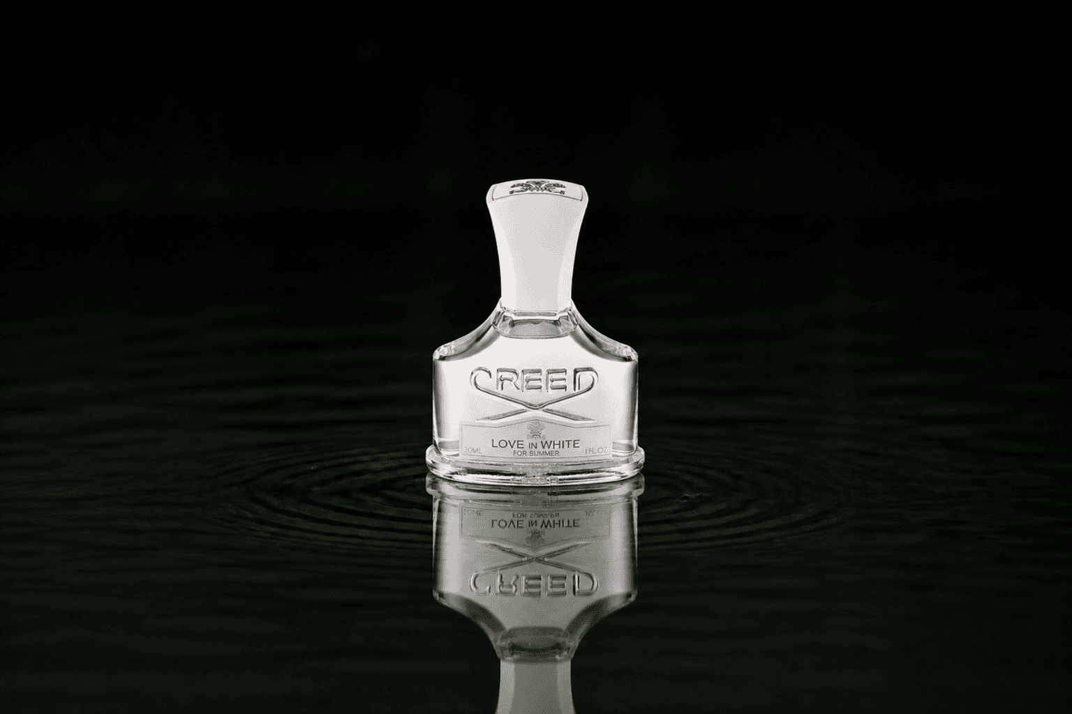 Creed Love in White fragrance bottle floating above dark water