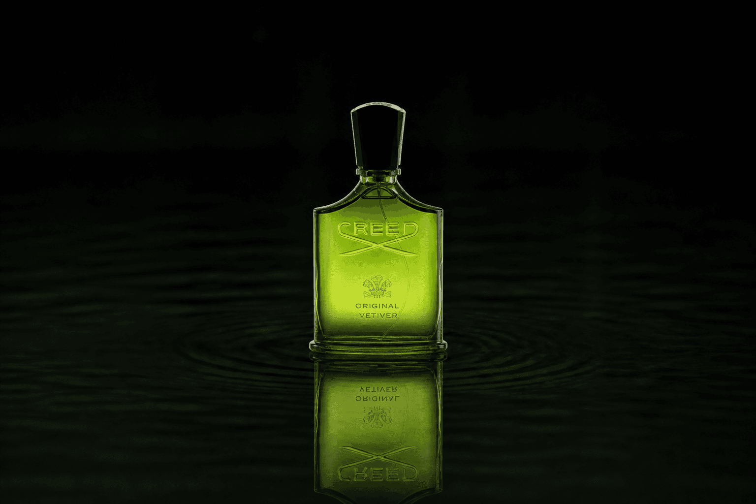 Creed Original Vetiver fragrance bottle floating above dark water