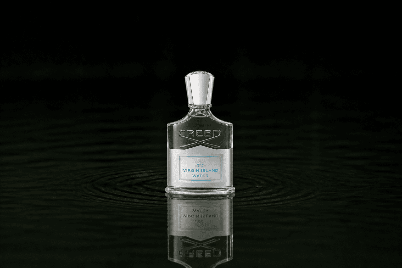 Creed Virgin Island Water fragrance bottle floating above dark water