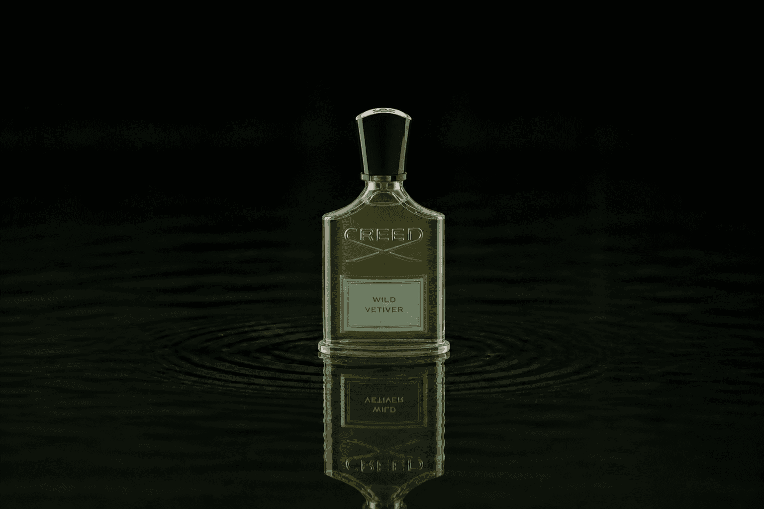Creed Wild Vetiver fragrance bottle floating above dark water