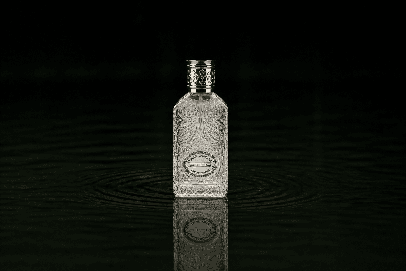 Etro White Magnolia fragrance bottle floating above dark water