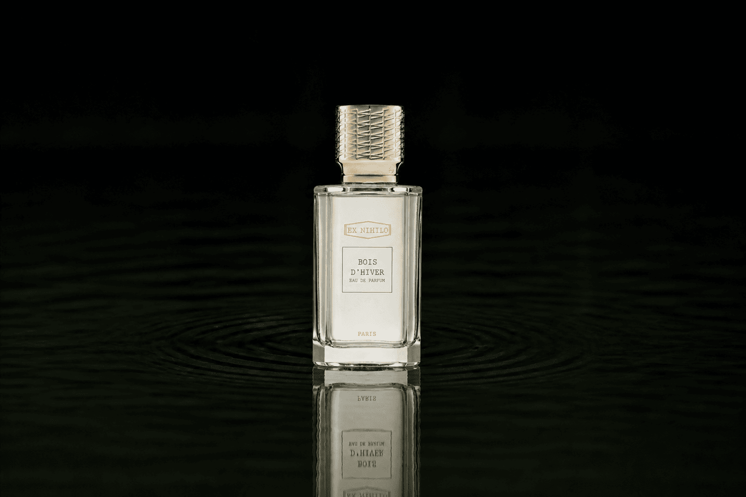 Ex Nihilo Paris Bois D'Hiver fragrance bottle floating above dark water