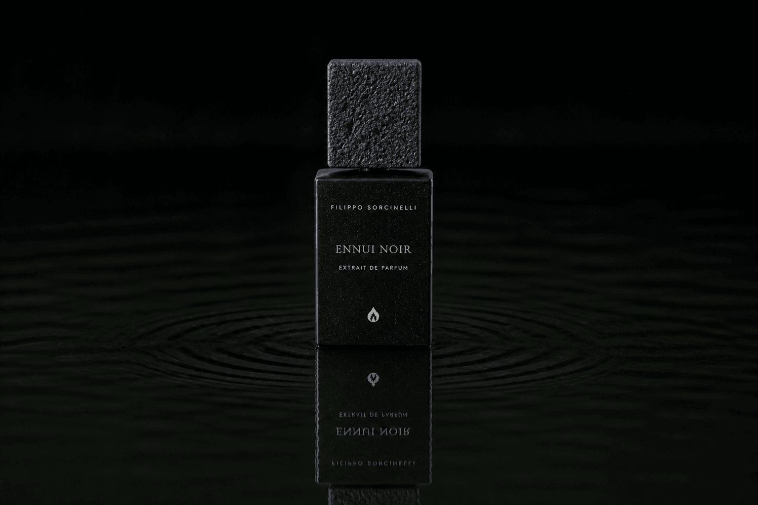 Filippo Sorcinelli Ennui Noir fragrance bottle floating above dark water