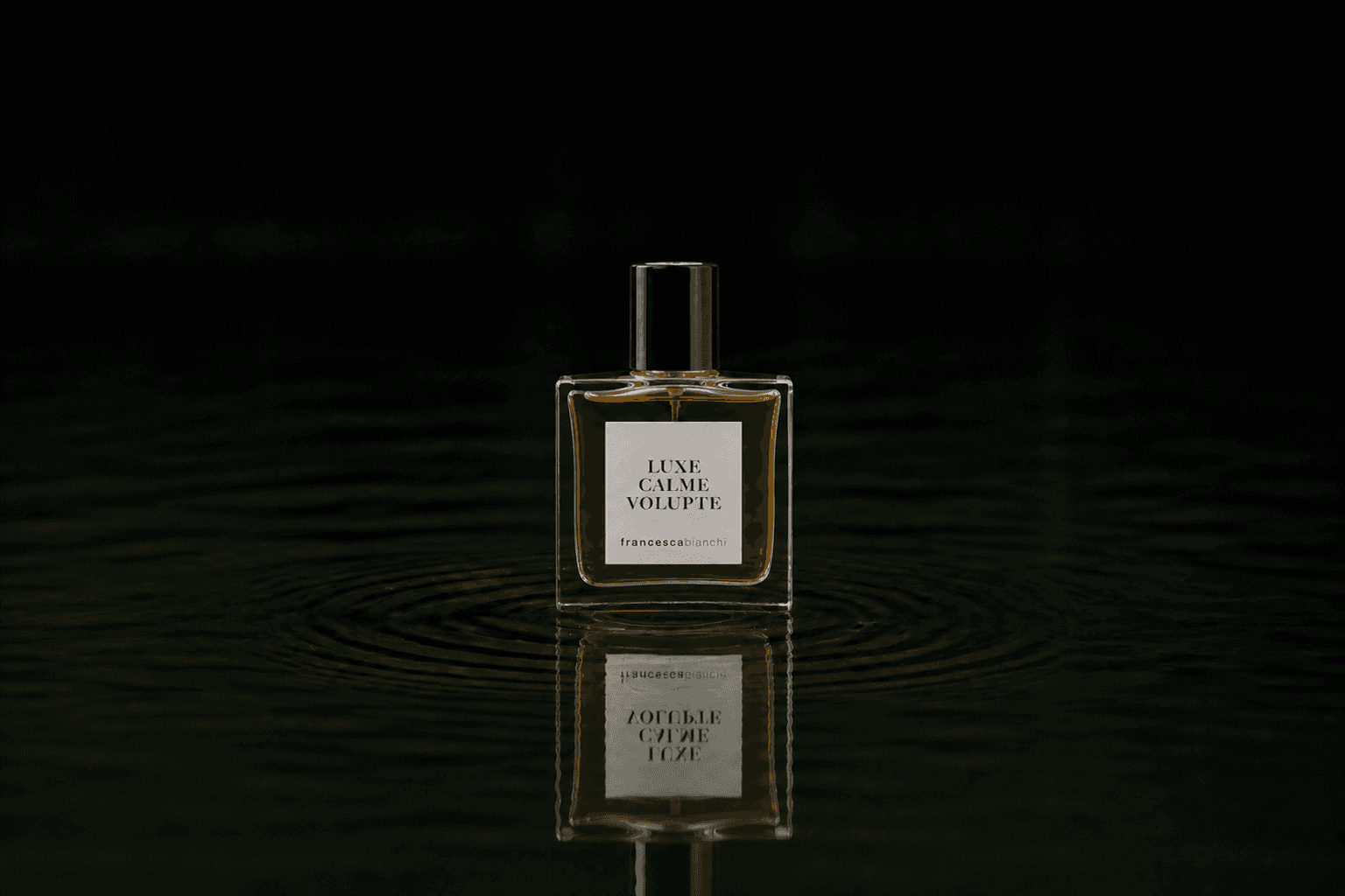 Francesca Bianchi Luxe Calme Volupte fragrance bottle floating above dark water