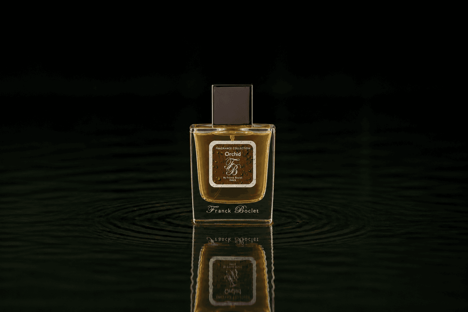 Franck Boclet Orchid fragrance bottle floating above dark water