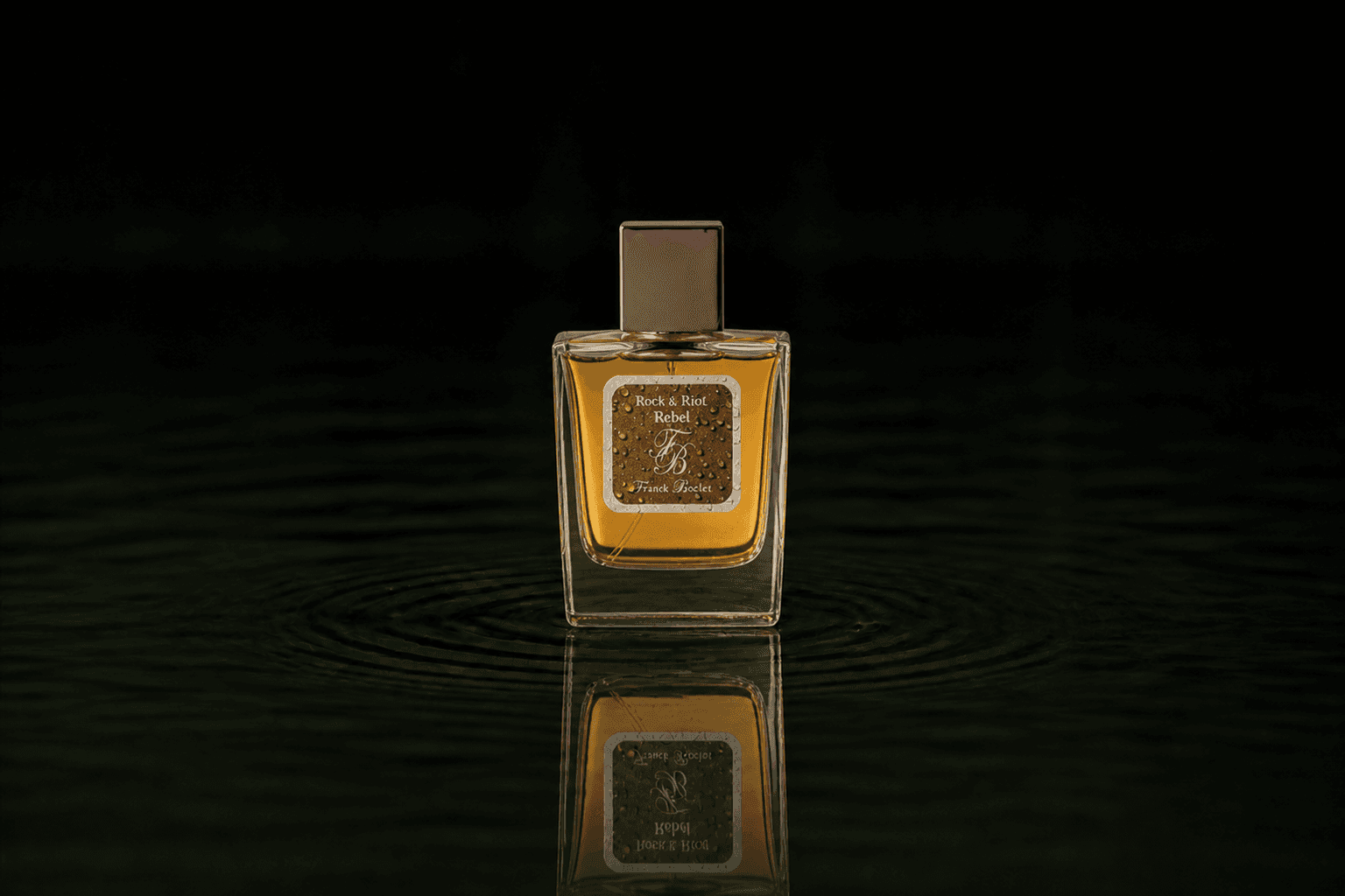 Franck Boclet Rock&Riot Rebel fragrance bottle floating above dark water