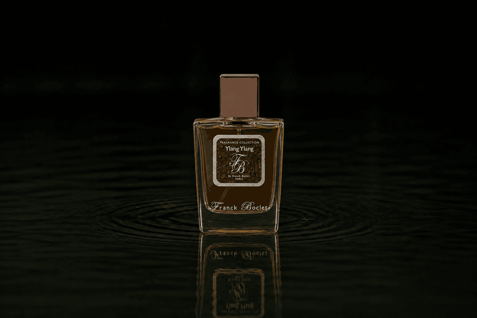 Franck Boclet Ylang Ylang fragrance bottle floating above dark water