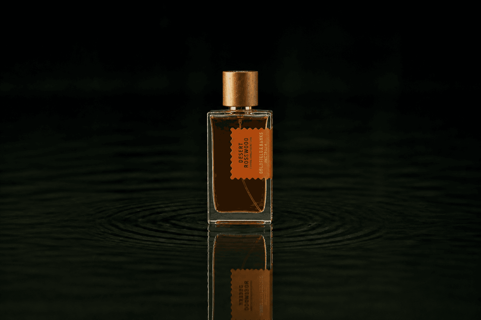 Goldfield & Banks Goldfield and Banks - Desert Rosewood fragrance bottle floating above dark water