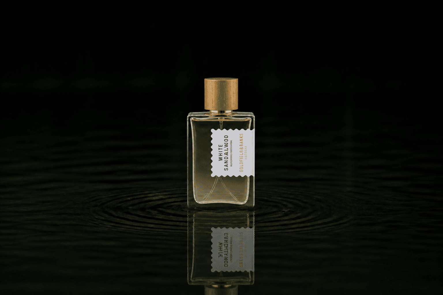 Goldfield & Banks White Sandalwood fragrance bottle floating above dark water