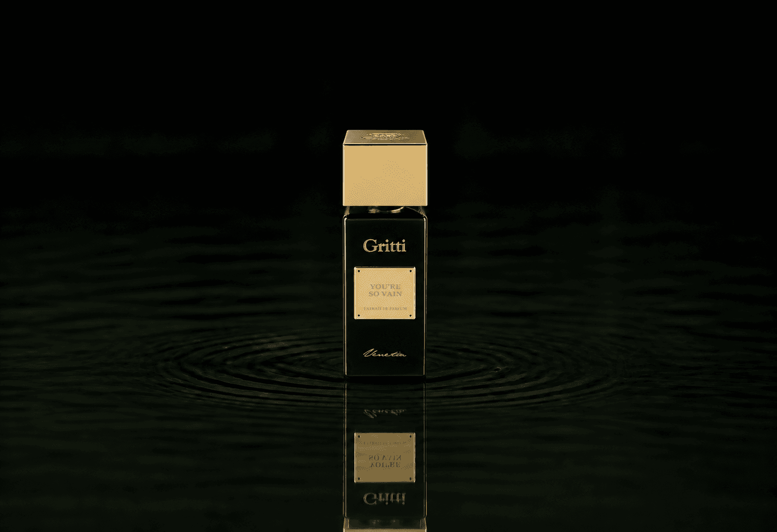 Gritti You're So Vain fragrance bottle floating above dark water