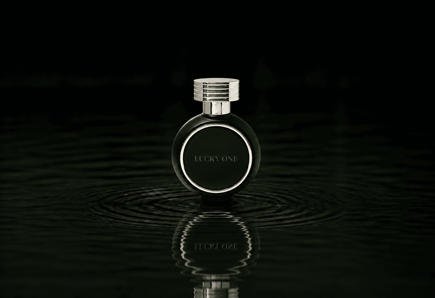 Haute Fragrance Company HFC Lucky One fragrance bottle floating above dark water