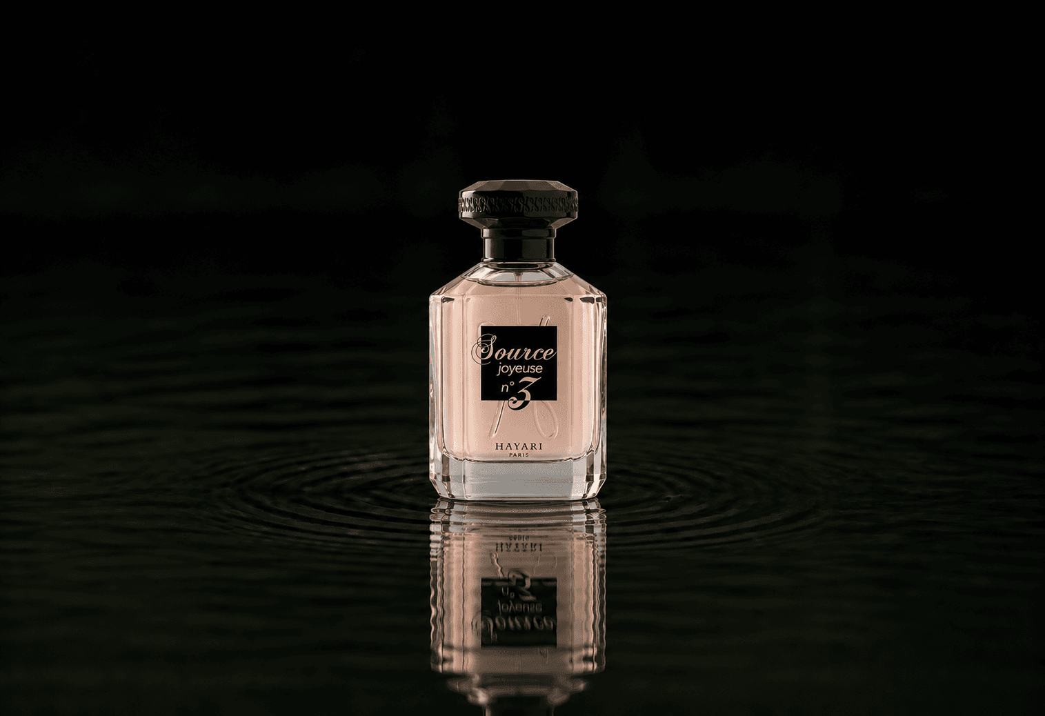 Hayari Source Joyeuse N3 fragrance bottle floating above dark water