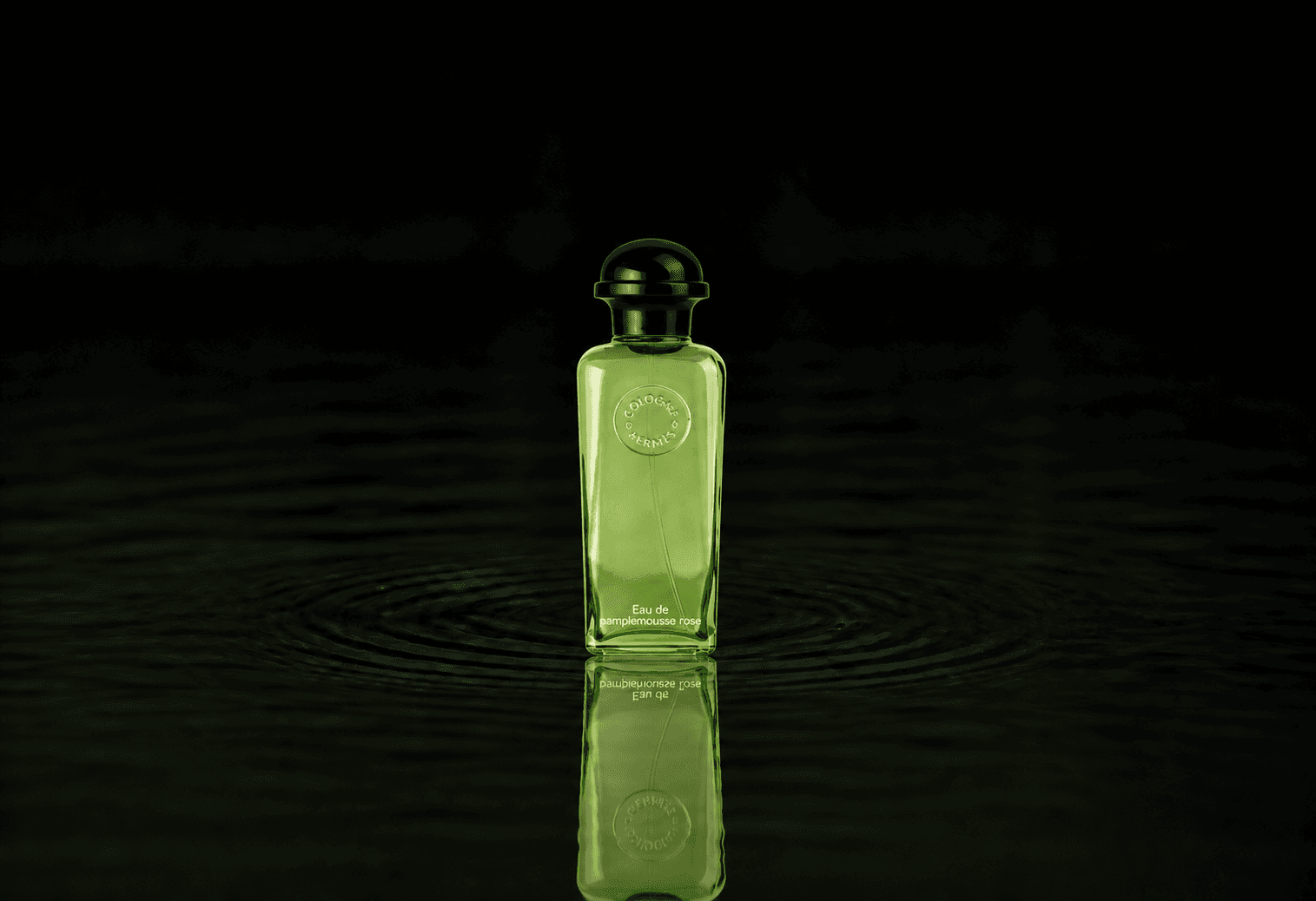 Hermes Eau De Pamplemousse Rose - Eau De Cologne fragrance bottle floating above dark water