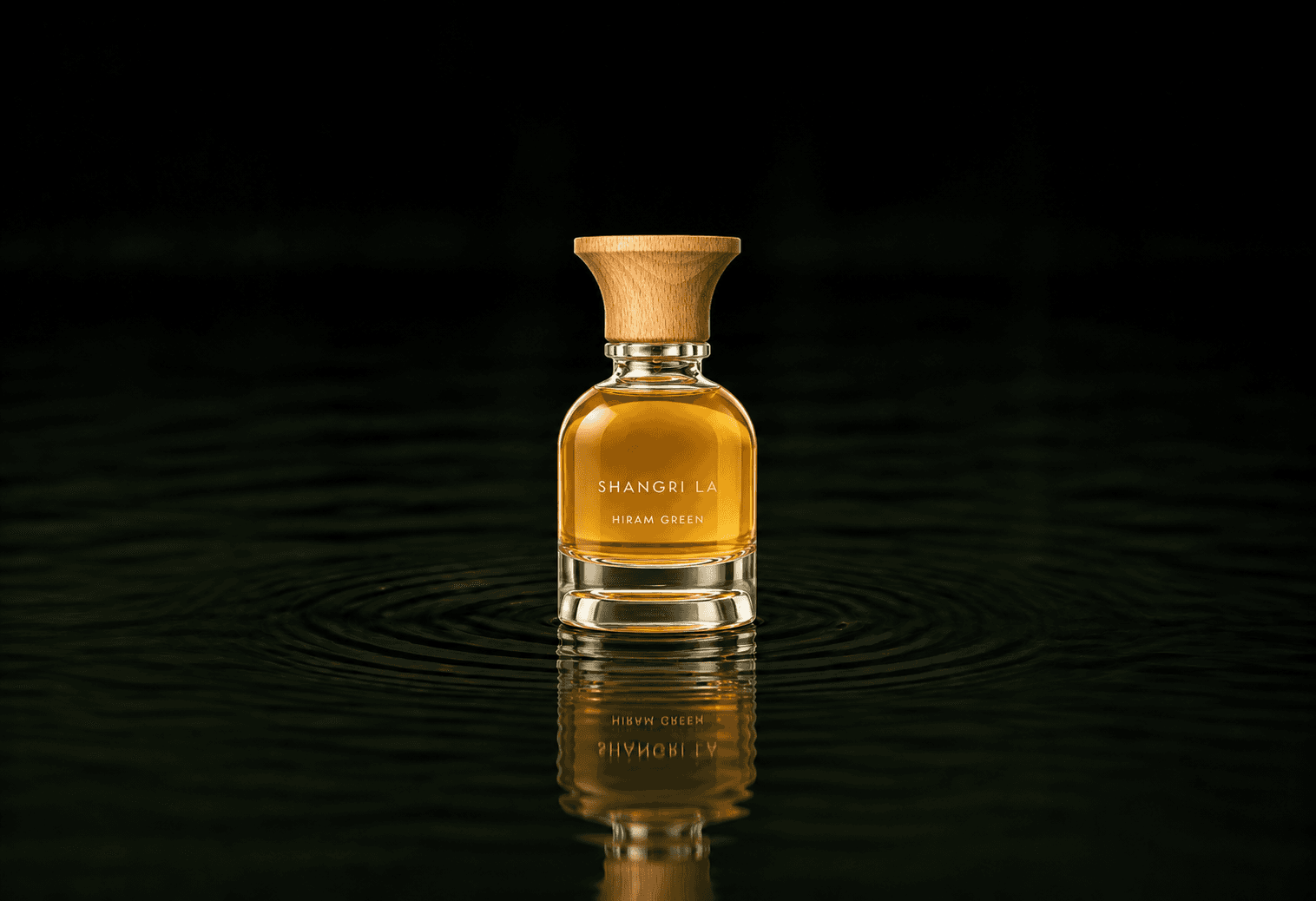Hiram Green Shangri La fragrance bottle floating above dark water