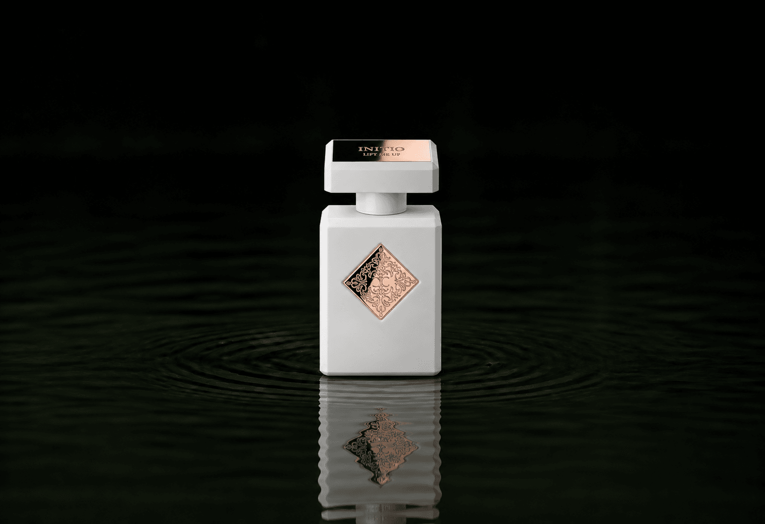 Initio Lift Me Up fragrance bottle floating above dark water