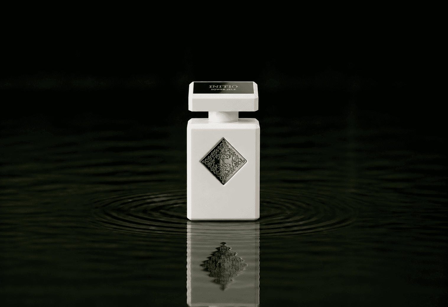 Initio Parfums Prives - Power Self fragrance bottle floating above dark water