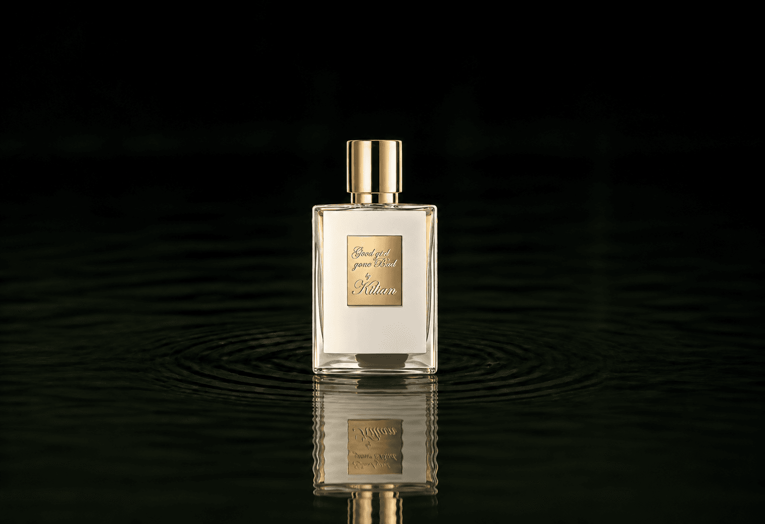 Kilian Good Girl Gone Bad fragrance bottle floating above dark water