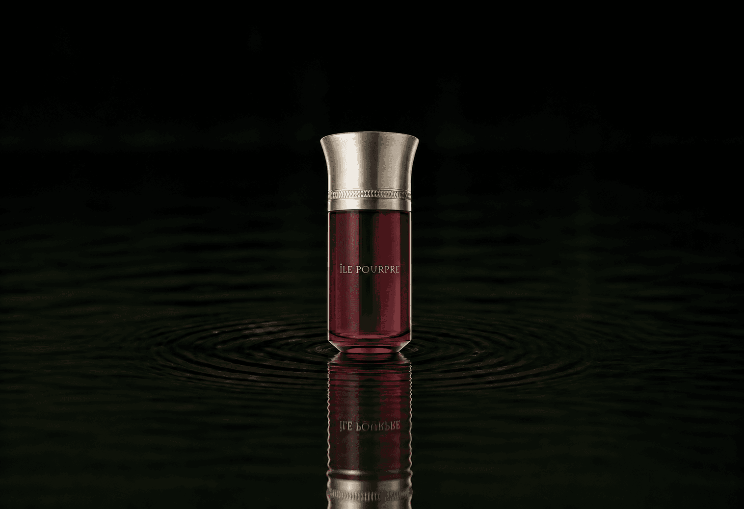 Les Liquides Imaginaires L'Ile Pourpre fragrance bottle floating above dark water