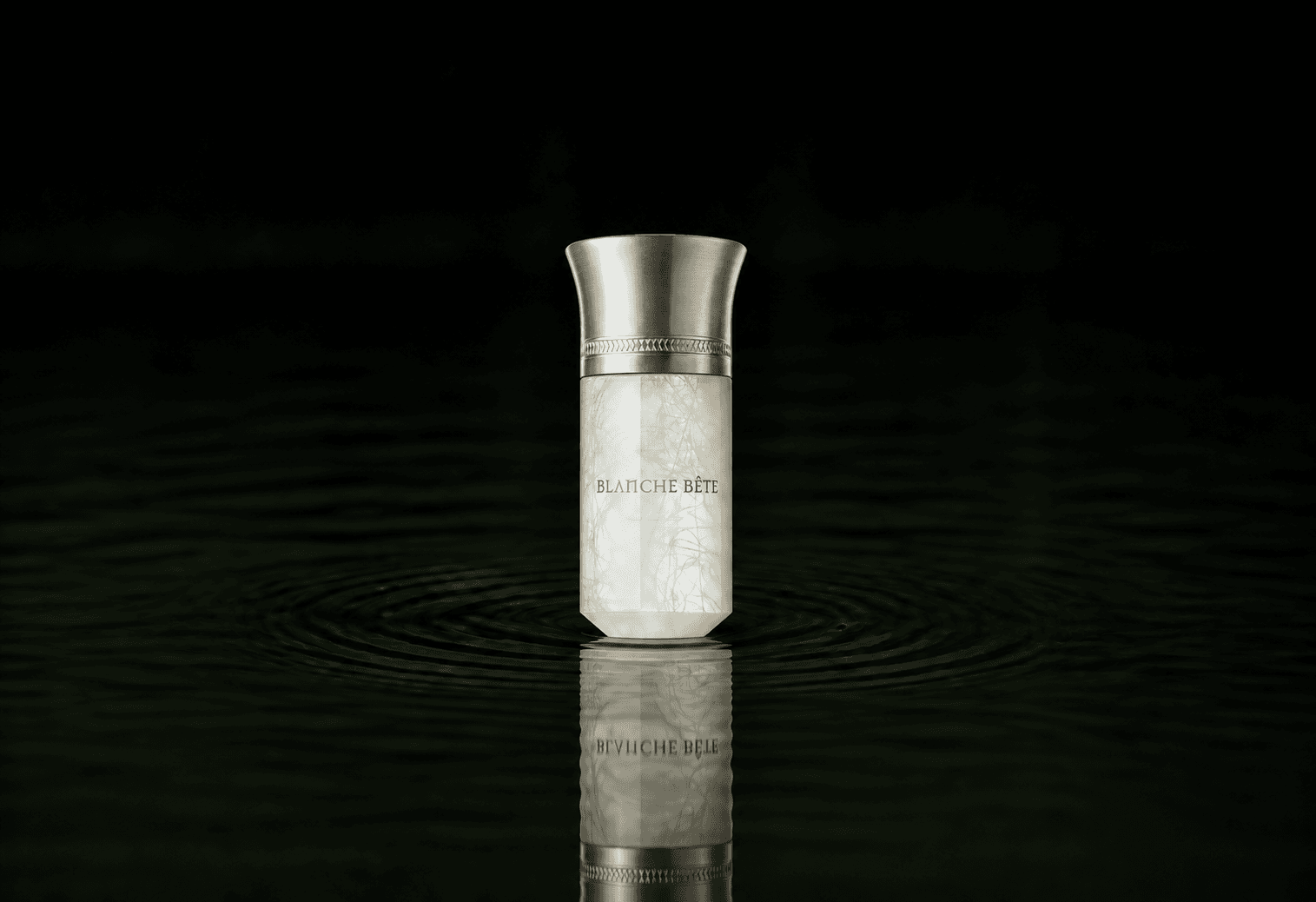 Liquides Imaginaires Blanche Bete fragrance bottle floating above dark water