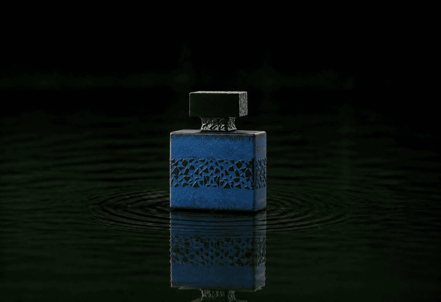 M.Micallef Desirtoxic fragrance bottle floating above dark water