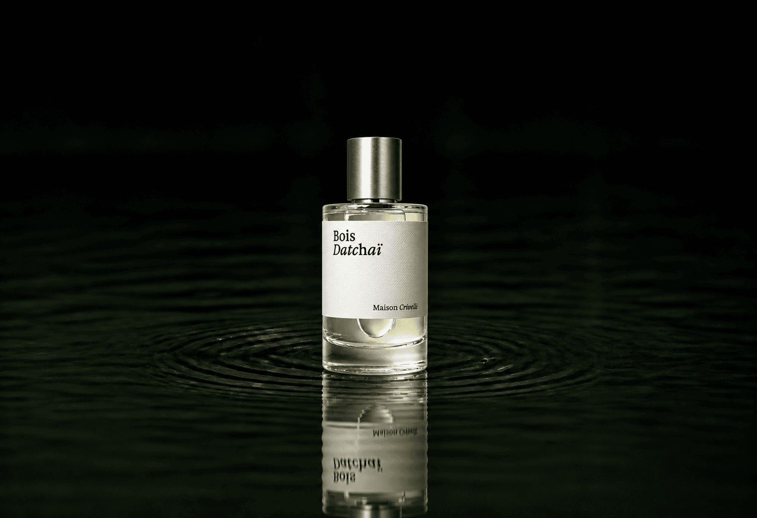 Maison Crivelli Bois Datchai fragrance bottle floating above dark water