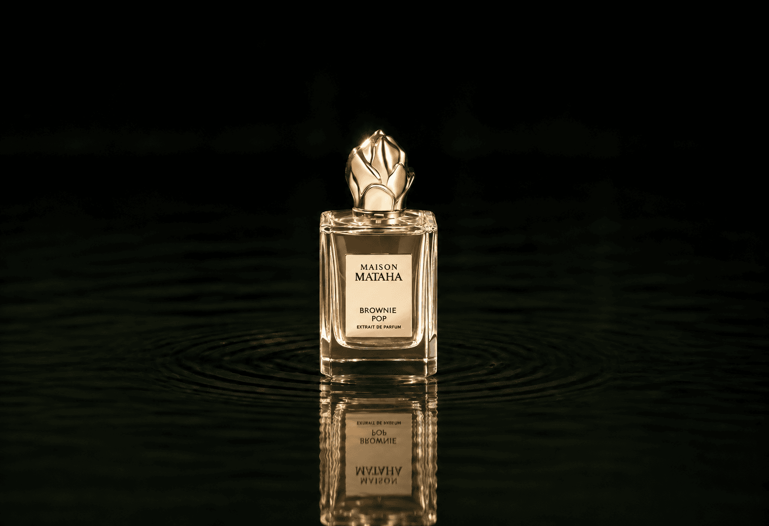 Maison Mataha Brownie pop fragrance bottle floating above dark water