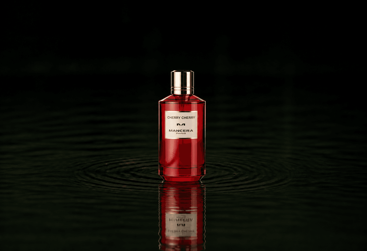 Mancera Cherry Cherry fragrance bottle floating above dark water
