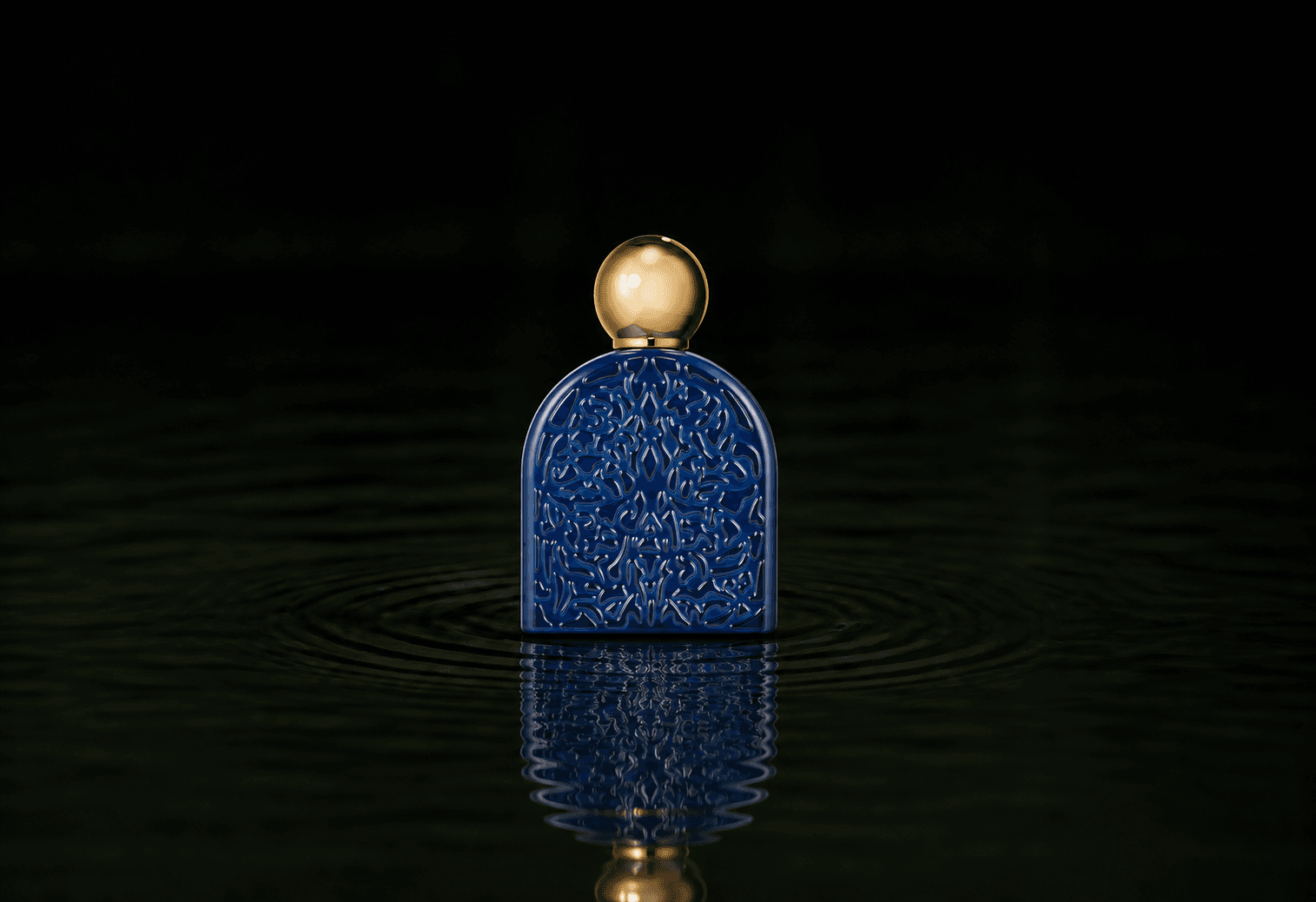 Micallef Secret Of Love Royal Blue fragrance bottle floating above dark water