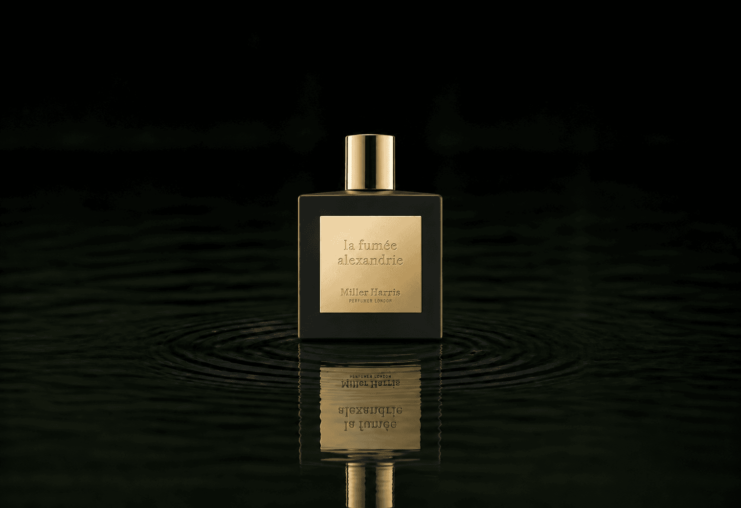 Miller Harris La Fumee Alexandrie fragrance bottle floating above dark water
