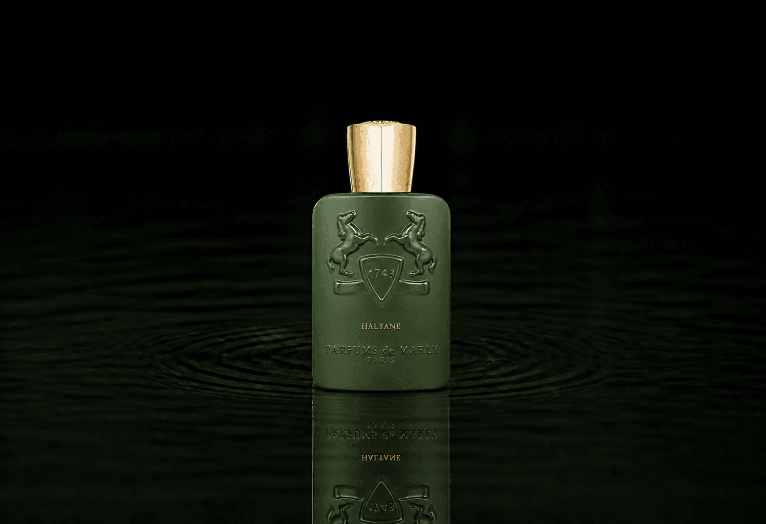 Parfums de Marly Haltane fragrance bottle floating above dark water