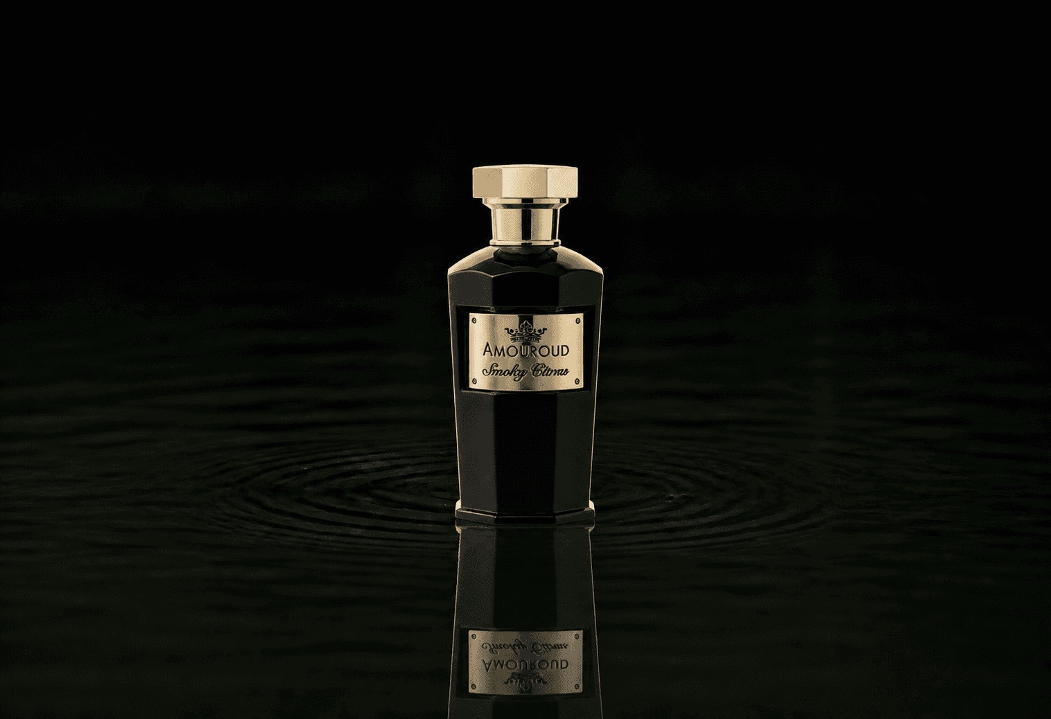 Amouroud Smoky Citrus fragrance bottle floating above dark water