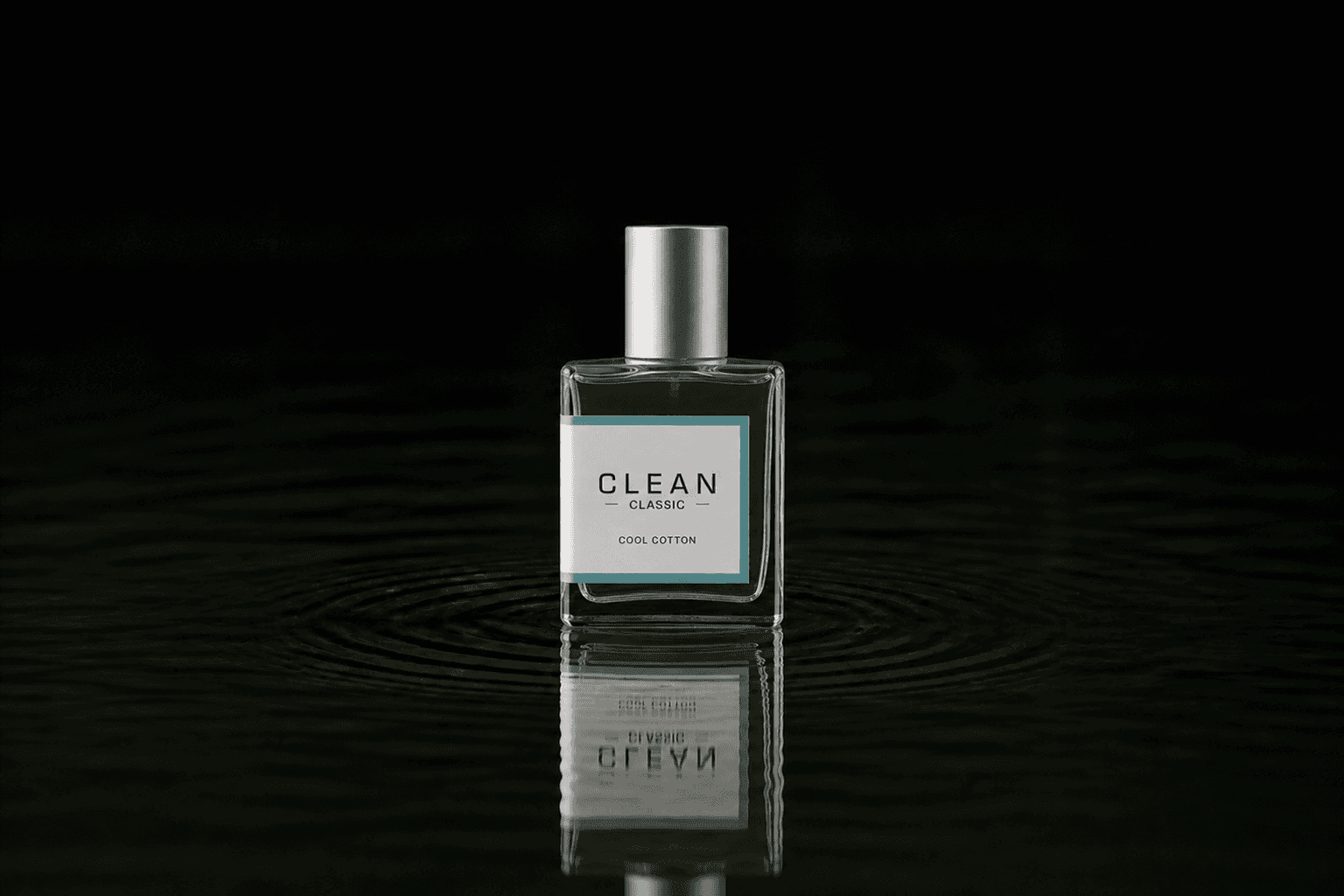 Clean Cool Cotton fragrance bottle floating above dark water