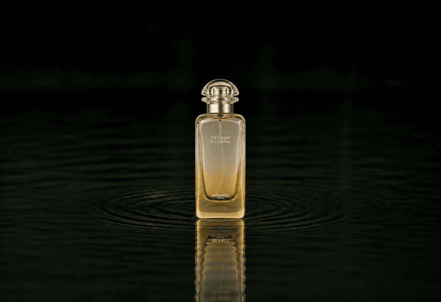 Hermes Un Jardin A Cythere fragrance bottle floating above dark water