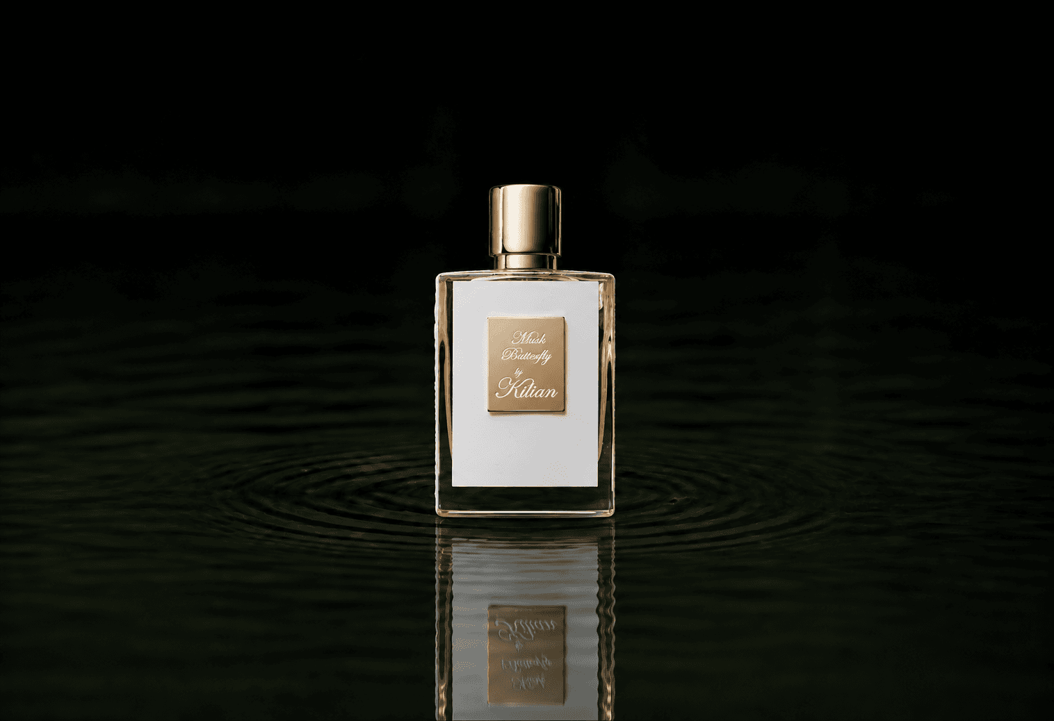 Kilian Musk Butterfly fragrance bottle floating above dark water