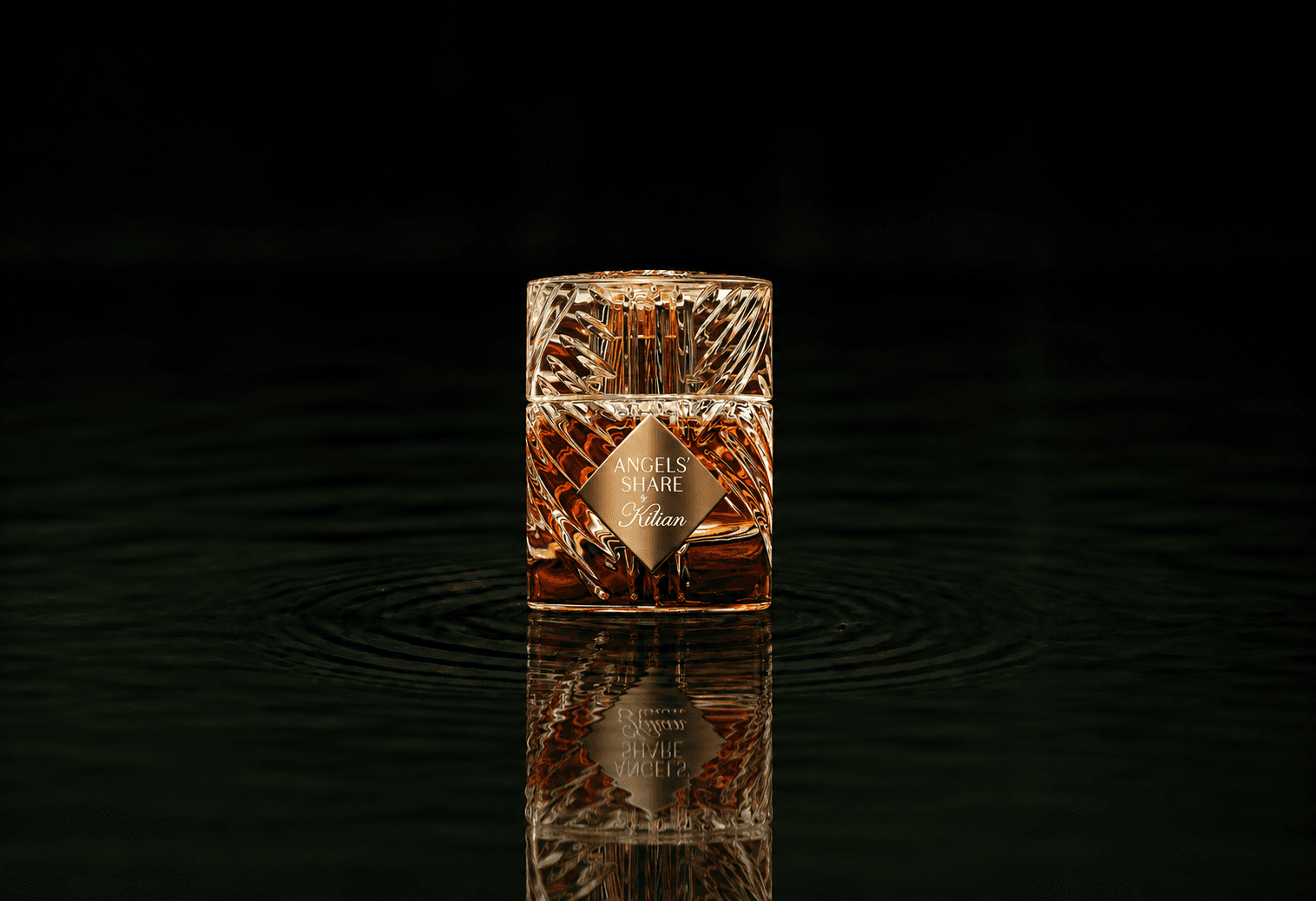 Kilian The Liquors - Angels Share fragrance bottle floating above dark water